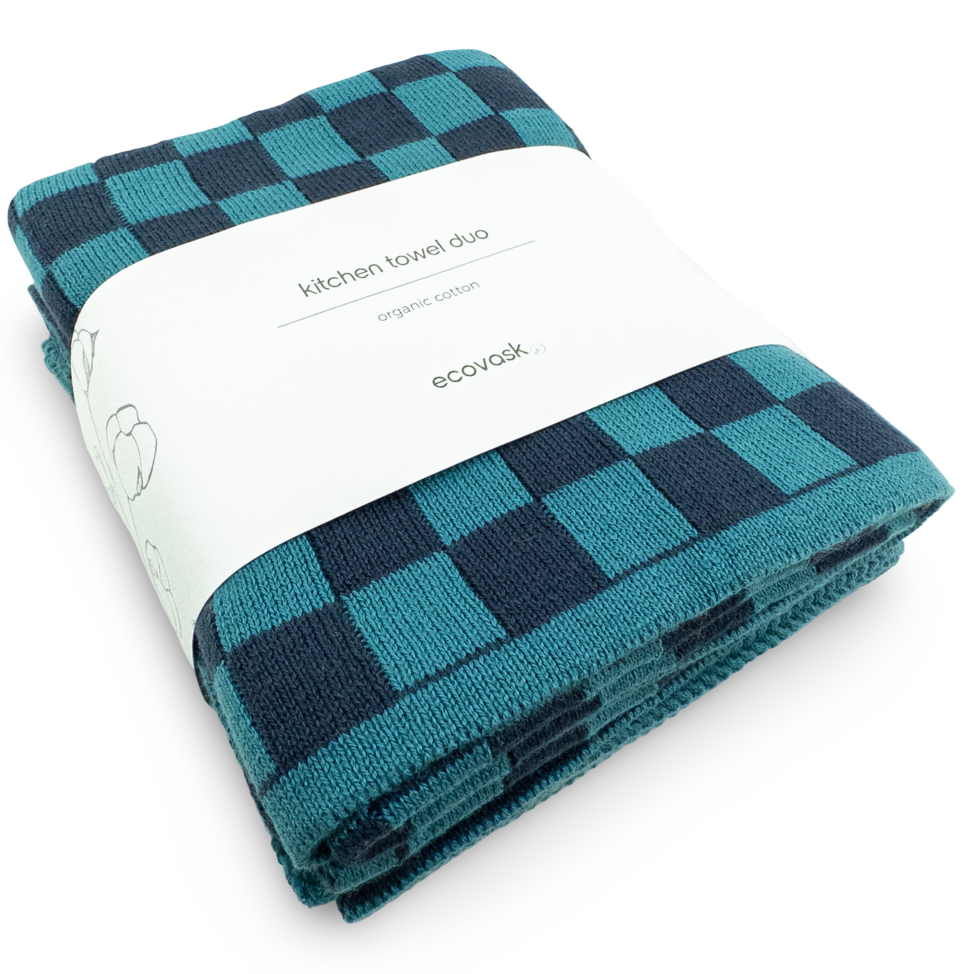 Folded teal and navy checkered kitchen towel with a white label on a white background